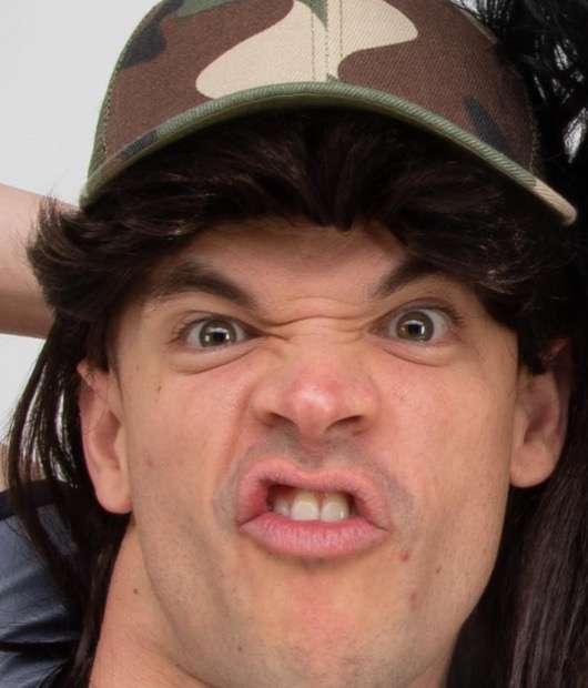 Samdog pulling an unhinged face under a camo cap