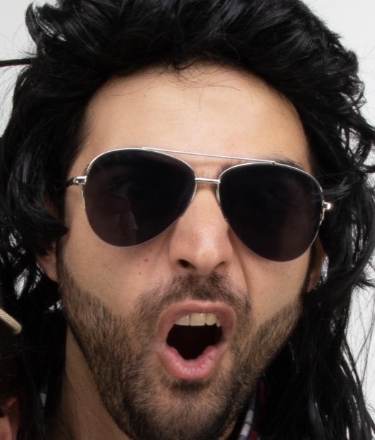 Tony in aviators, mouth wide open, black mullet everywhere